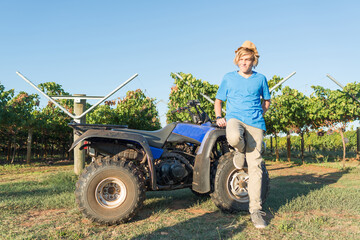 Young farmer standing near quad bike