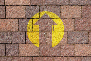 arrow symbol pointing upwards in yellow color on Sandstone pavement. motivational symbol.