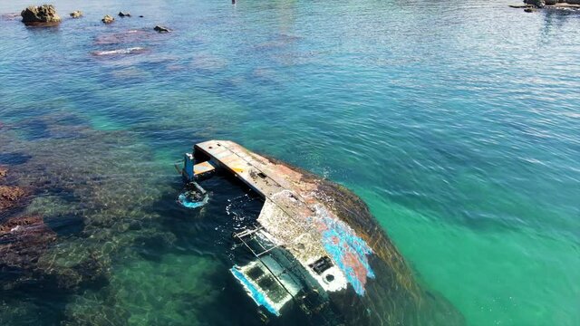 Aerial Tilt Up Scenic Shot Of Wrecked Ship In Sea During Sunny Day - Tel Aviv, Israel