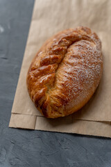 Bakery pastries on grey background. Freshly cooked bakery with cherry for delivery or take away. Home cooked bakery for morning breakfast. Copy space. Vertical shot. Selective focus