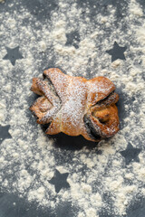 Bakery pastries on grey background with flour. Freshly cooked bakery. Home cooked bakery for morning breakfast. Copy space. Vertical shot. Selective focus