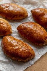 Bakery pastries on white and brown background. Freshly cooked bakery. Home cooked bakery for morning breakfast. Copy space. Vertical shot. Selective focus