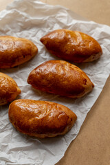 Bakery pastries on white and brown background. Freshly cooked bakery. Home cooked bakery for morning breakfast. Copy space. Vertical shot. Selective focus