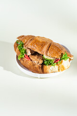 Croissant with terriyaki chicken on a white plate