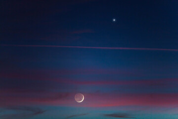 Obraz na płótnie Canvas Crescent young Moon and planets on colorful sky.