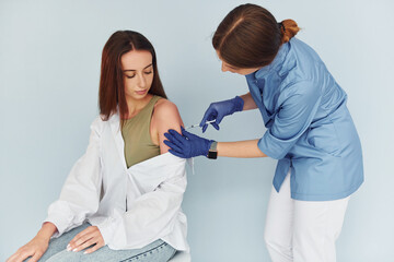 SImple but effective procedure. Doctor in uniform making vaccination to the patient