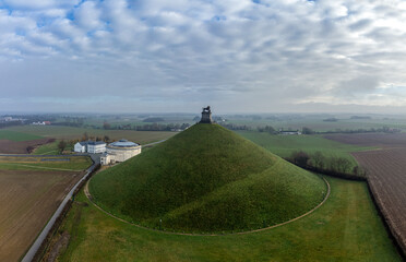  Lion's Mound with farm land around and dramatic clouds. Butte Du Lion on the battlefield of...