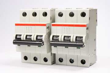 3-pole  current circuit breakers on a white background.