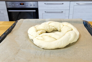 Raw Savory Christmas pie in the shape of a wreath, stuffed with cottage cheese, spinach and salted red fish on a baking sheet. close up