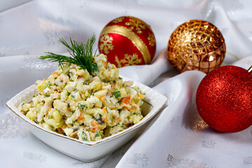 Classic New Year's table with traditional salad and christmas decorations on a white tablecloth. Russian dishes for New Year. Olivier salad. close up