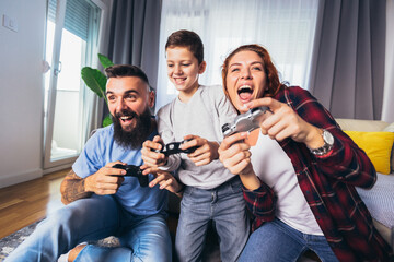 Happy family playing video games at home and having fun together.