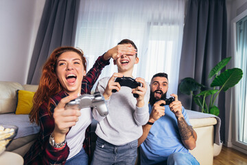 Fototapeta premium Happy family playing video games at home and having fun together.