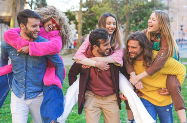 Fototapeta premium Group of friends joking together while spending a beautiful day in the park - Focus on afro girl