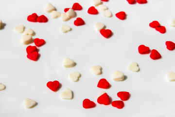 Many small white and red hearts on a white background. The concept of love and romance. Romantic background composition. Valentine's Day