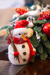 Cute snowman near a fir branch with toys
