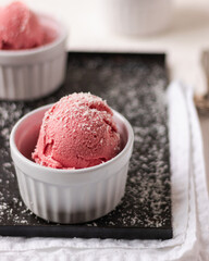 Strawberry ice cream ball with coconut in a bowl, on a white background. home made ice cream. healthy. clean eating. vegan. plant based.