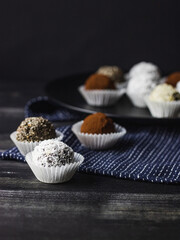 Energy protein balls with healthy ingredients on dark background. Home made with dates, peanut butter, flax and chia seeds, oats, almond and chocolate drops