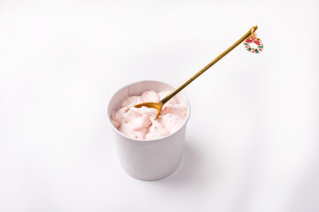 Fruit ice cream in a paper cup with a teaspoon