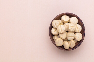 Fototapeta na wymiar Alternative medicine tablets on a wooden spoon.