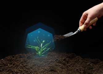 green sprout in a blue vacuum and a female hand with a shovel of earth on a black background....