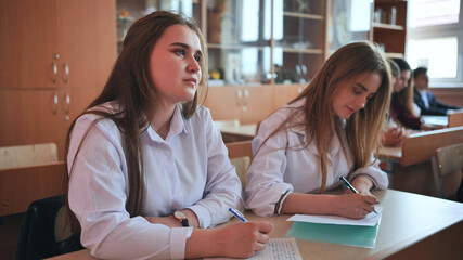 Pupils of the 11th grade in the class at the desks during the lesson. Russian school.