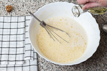 Cooking pancakes in a pan, cooking from grandmother, selective focus, add butter to the dough. Step 2