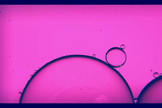 Oil bubbles, streaks on the water in a light purple light, macroscopic
