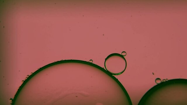 Oil bubbles, streaks on water in light brown light, macroscopic