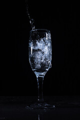 Wineglass with water splash on black background 