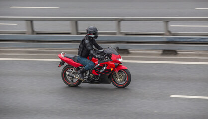 Fototapeta na wymiar Biker in Helmet Rides Motorcycle