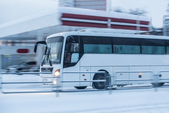 Tourist bus moves in winter along a snow-covered street