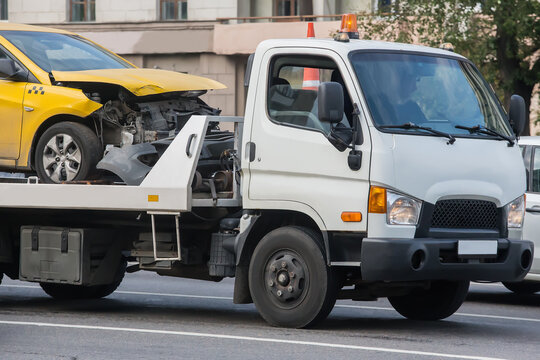 Tow truck transporting broken taxi car