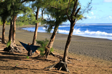 homme sur hamac contemplant  l'océan indien à la Réunion tranquillement en train de lire : instant seul au monde 