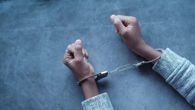 man's hand with handcuff on black background.