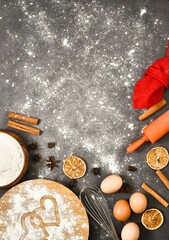 Valentine's Day baking culinary backgrounds. Ingredients for cooking -whisk, egg, cinnamon sticks, star anise, flour, napkin on gray kitchen table. Baking recipe for pastry. Vertical banner.Copy space