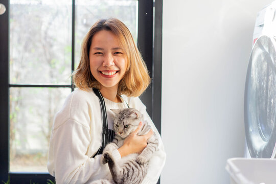 close up beautiful asian woman smile with charming adorable cat in living room for cat lover and lifestyle people concept