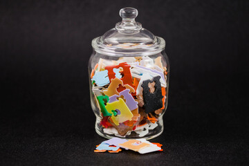 a glass jar filled with lots of multicolored plastic bread tags