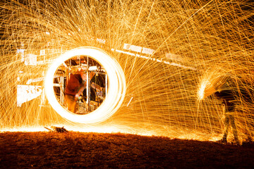 Stahlwolle Kreis mit Funken und Feuer und Person mit Regenschirm

