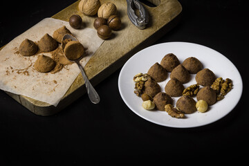 Chocolate truffles and nuts cooked at home. Chocolate truffles on a dark background.