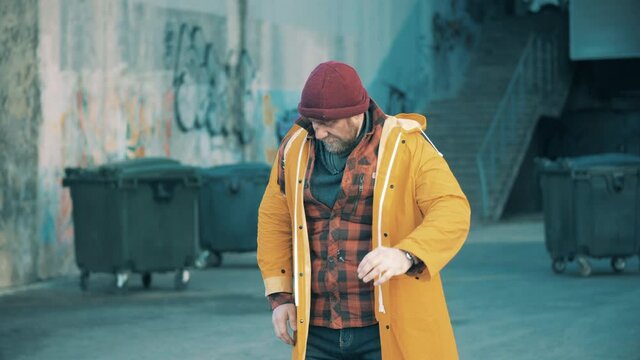 A homeless man takes a massive bag off the ground