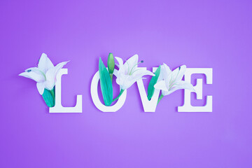 Fototapeta premium Colorful love background. Floral Greeting card. Happy Women's Day. Spring flower flat lay holiday background with word Love. Nature Trendy Design. Happy Valentine's Day.