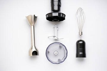 Immersion hand blender with different attachments on a white background. Top view.