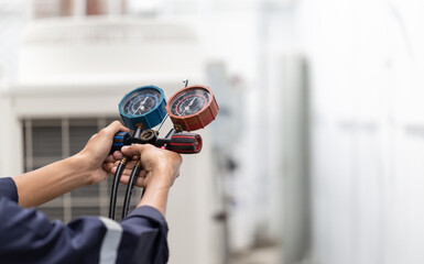 Technician is checking air conditioner ,measuring equipment for filling air conditioners.