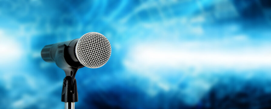 Microphone with stage lighting background for performance concept of speech comment and public speaking