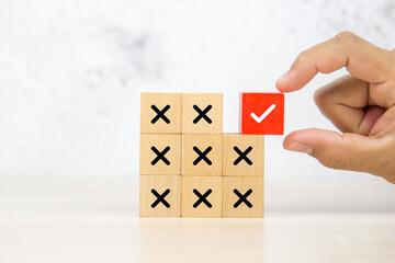 Hand choose wooden block stack with check mark and cross symbol for customer survey service and...