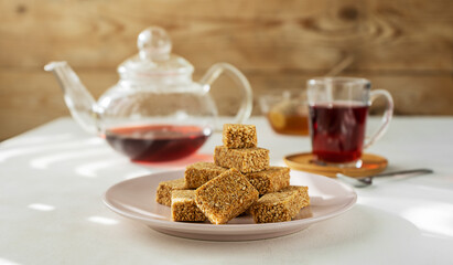Eastern sweets - sesame mini-bars on plate with fruit tea and honey