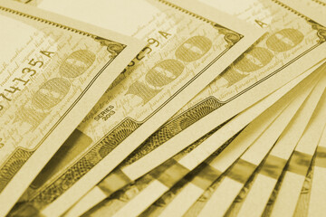 American banknotes of one hundred dollars. Fragment of notes close-up. Focus on digit 100. Economy money savings and US dollar. Light olive tinted background or backdrop. Macro