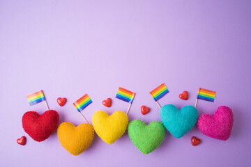 Rainbow heart shapes and rainbow flag on violet background. Happy Valentines day, inclusiveness and...