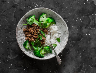 Ground beef, basmati rice, broccoli and cilantro - delicious asian style lunch on a dark...