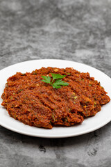Chili paste on a dark background. spicy paste. A kind of adjika. Turkish cuisine appetizers. Vertical view. Close up